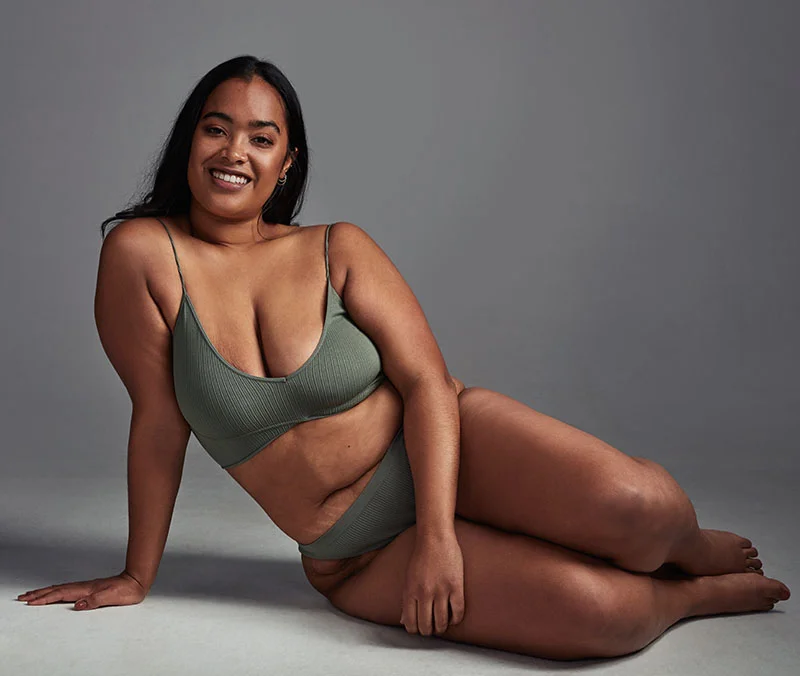 African American woman posting leaning back in olive colored bikini
