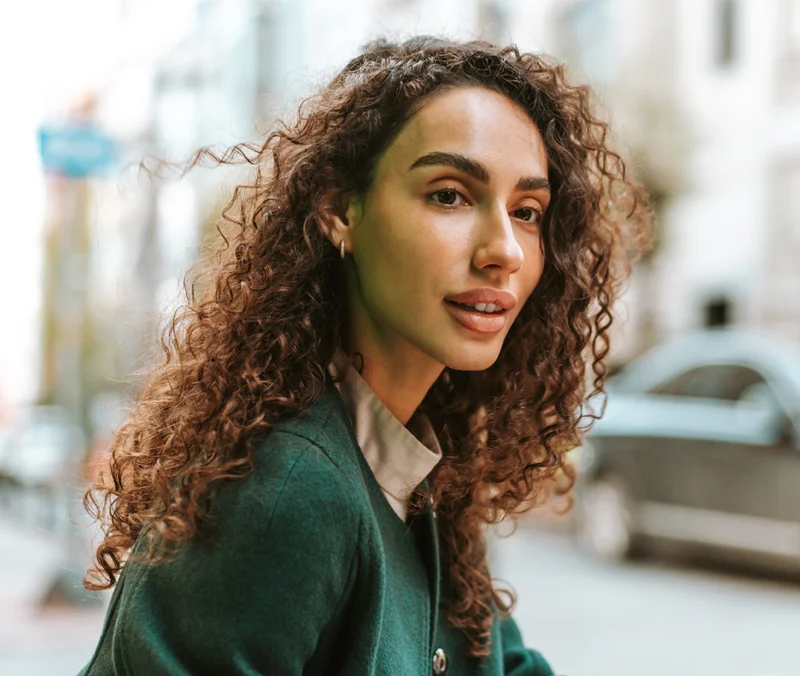 Woman with thin face and long curly hair