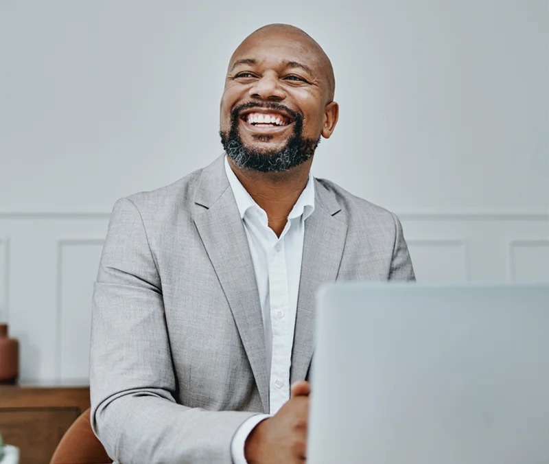 Man in a stylish gray suit working from a laptop